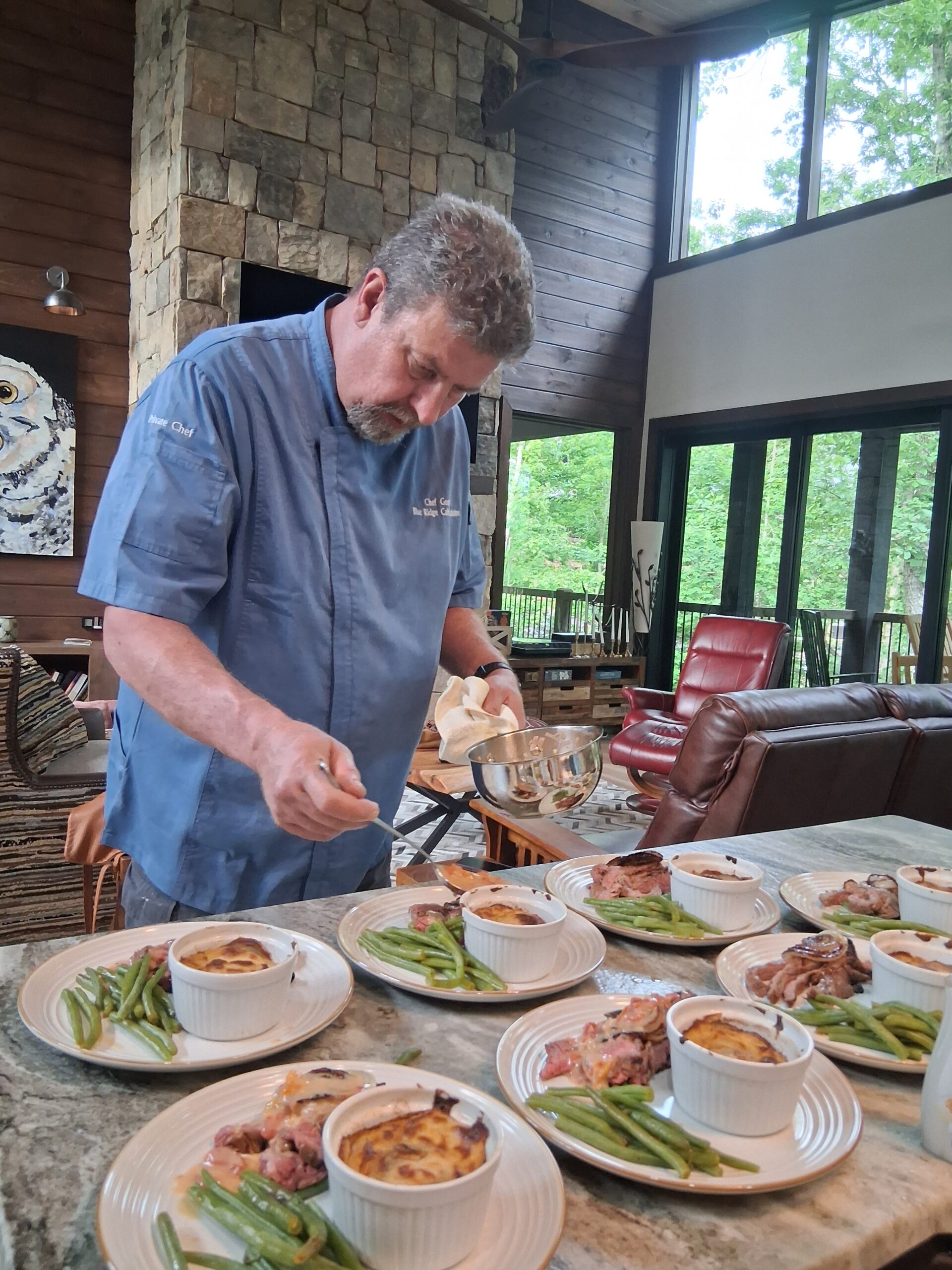 Private Chef George Lochli of Blue Ridge Cabin Cuisine plating the entree at a Full-Service Private Chef Experience prepared at a vacation rental in Blue Ridge, GA.